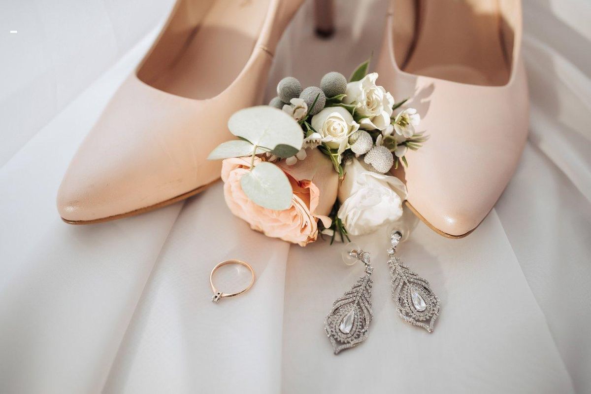 Accessoirisez votre robe avec élégance : chaussures nude, bijoux raffinés, et fleurs délicates.