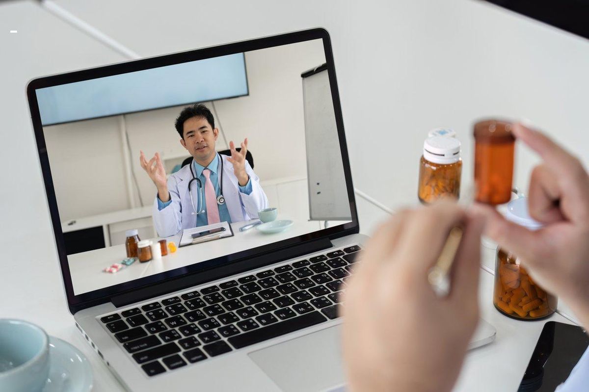 Consultation médicale en ligne : un médecin guide un patient dans un cadre privé via visioconférence sécurisée.