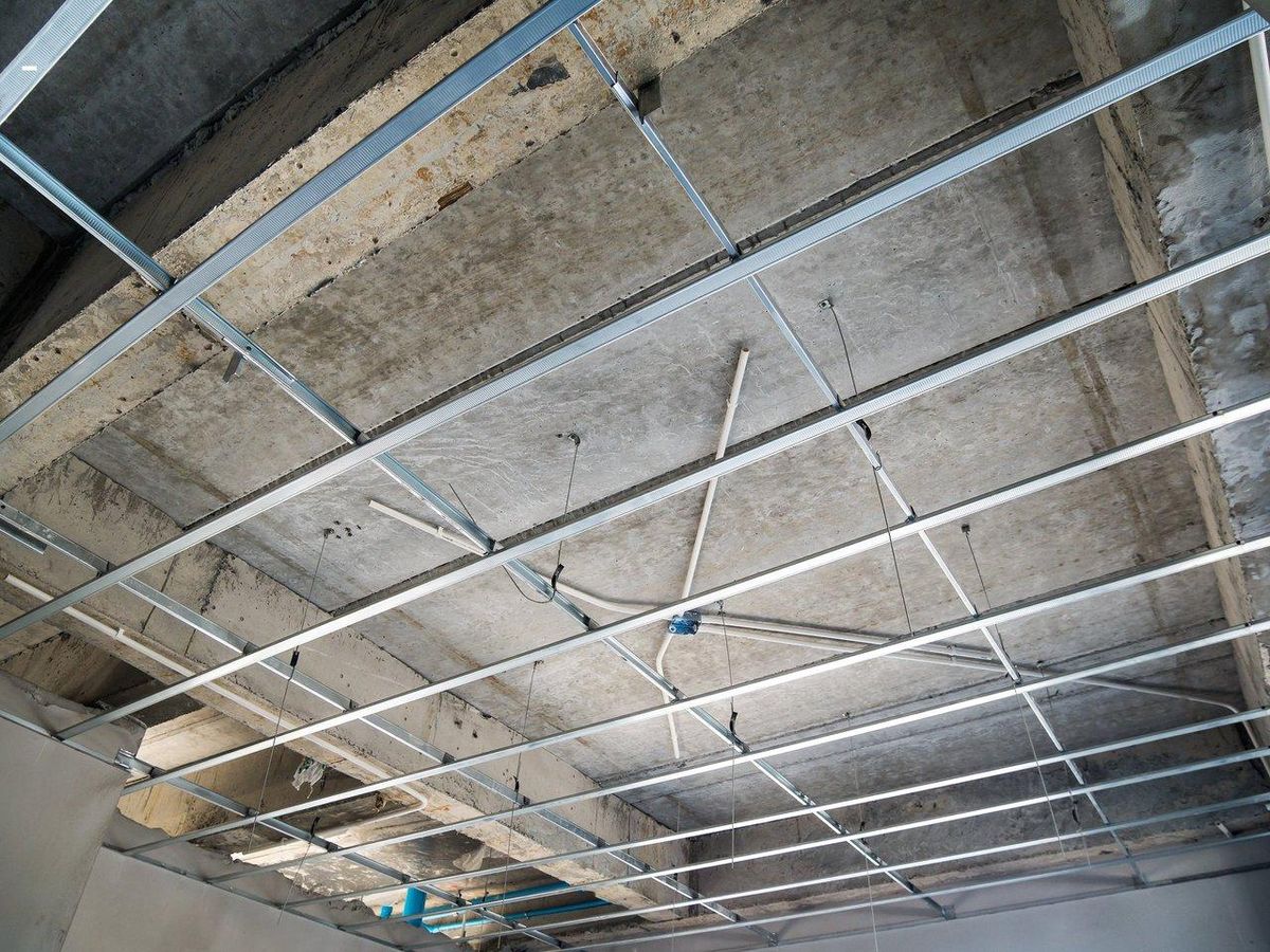 Installation d’un crochet renforcé au plafond pour une suspension sécurisée en bondage domestique.