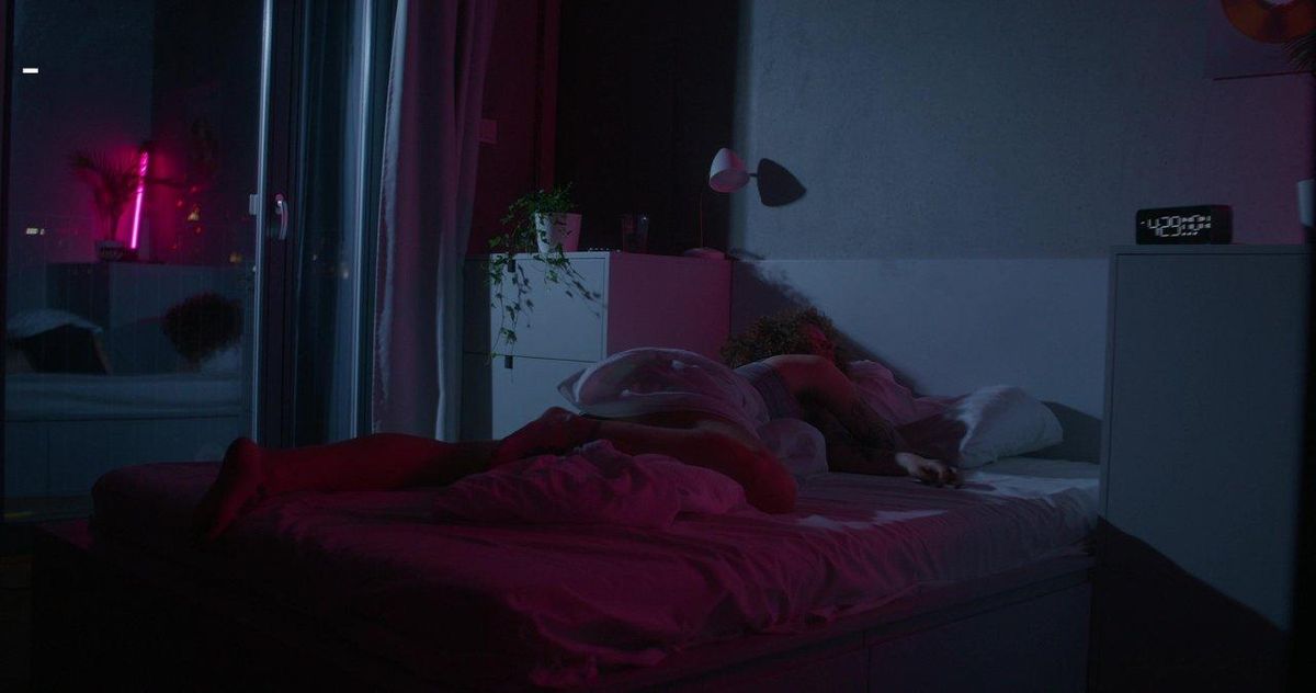 Scène de shibari dans une chambre tamisée, illustrant un jeu de rôle BDSM entre partenaires complices.