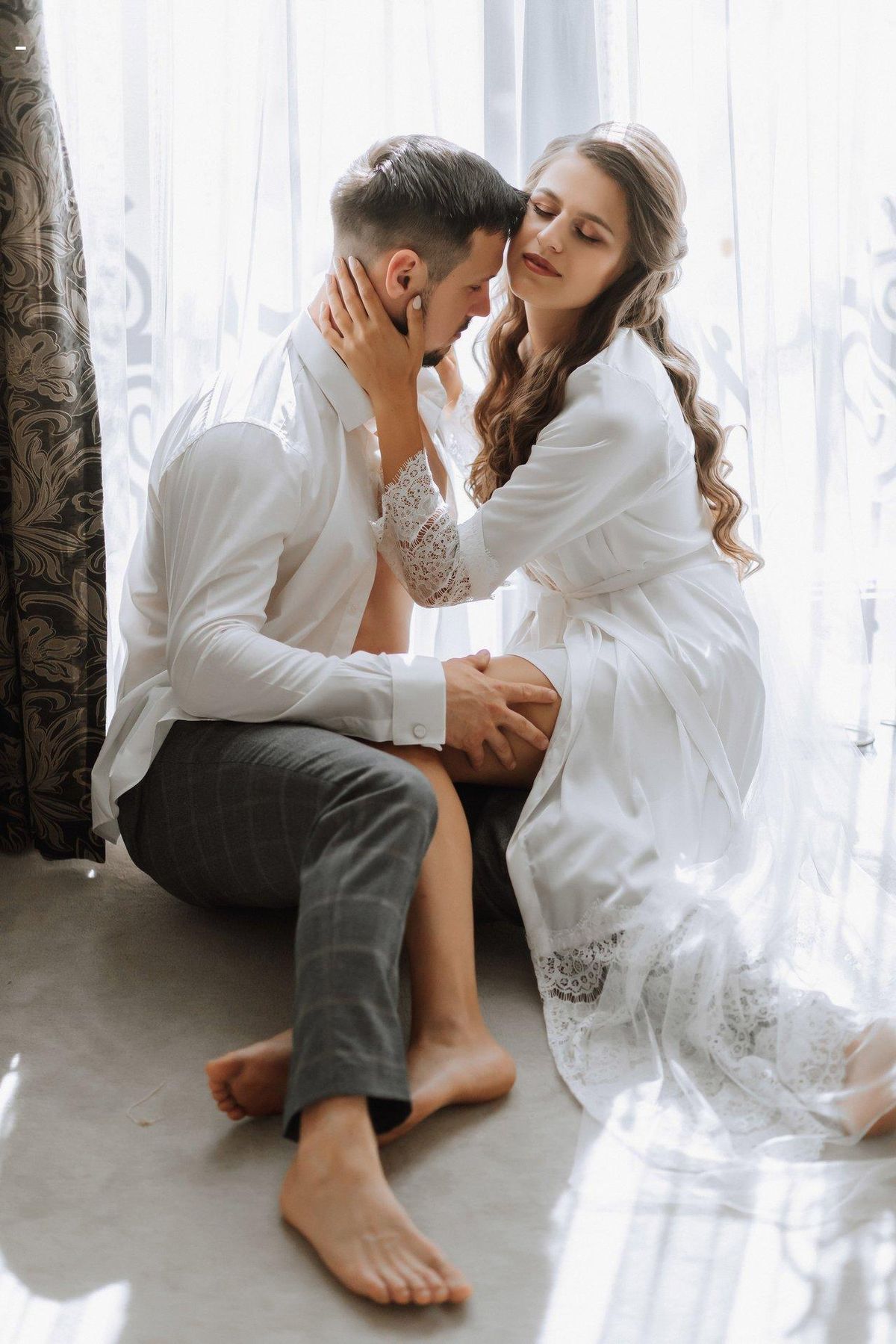 Un couple élégant et complice partage un moment intime, avec un bijou anal discret à proximité.