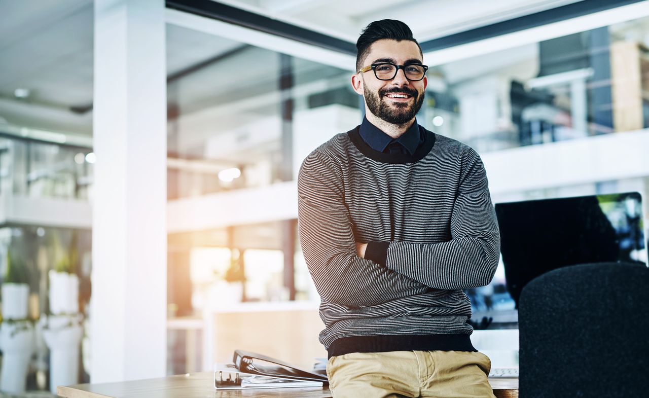 Homme d'une quarantaine d'années au regard bienveillant, chemise casual, assis dans un bureau chaleureux aux tons chauds, lumière douce