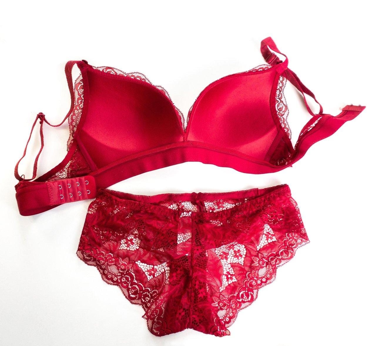 Ensemble lingerie en soie assorti pour couples curieux, posé élégamment sur un lit blanc.